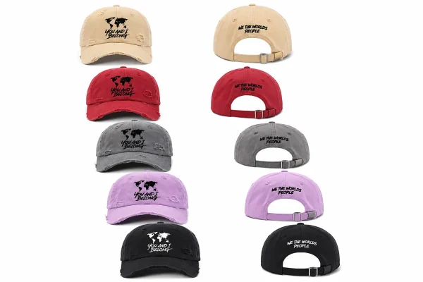 Front and back product views of the You and I Belong distressed baseball caps shown in all five available colors: khaki, red, grey, light purple, and black. The front displays the world map logo, and the back displays the embroidered phrase "We The World's People" above the adjustable strap.