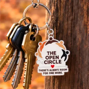 Close-up of The Open Circle key charm reading There's always room for one more, hanging from a ring of keys
