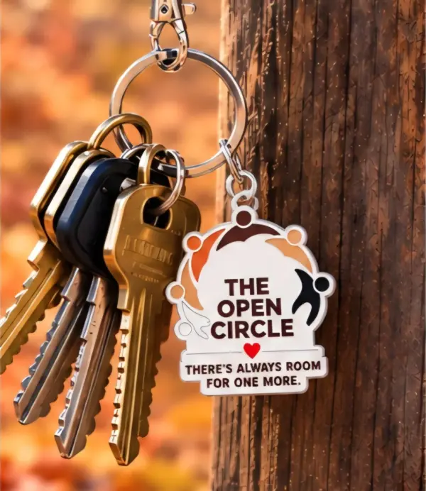 Close-up of The Open Circle key charm reading There's always room for one more, hanging from a ring of keys